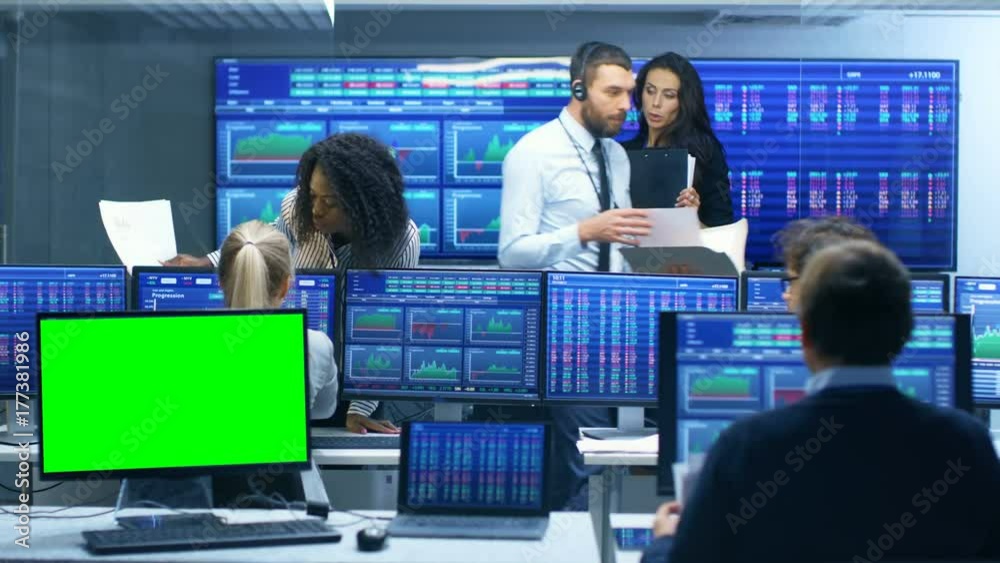Aufkleber multi-ethnic team of traders is busy working at the stock exchange office, one display is a green sc