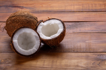 Ripe half cut coconut on a wooden background. Ripe half cut coconut on a wooden background. Space for text