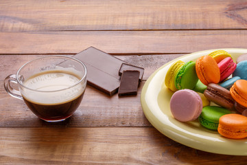 colorful macaroons, cup of coffe, chocolate bar