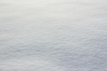 Texture of fresh snow covering ground thickly on frosty winter morning outside. Horizontal color photography.