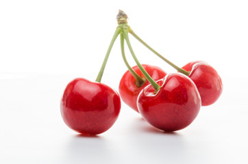 Fototapeta na wymiar Cherries on a white background. Red berries with green twigs.