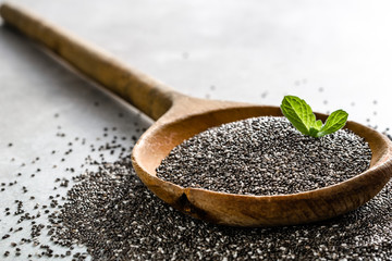 Healthy food background - chia seeds on wooden spoon, close-up, vegetarian diet concept