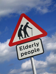 Elderly people road traffic sign against blue sky and clouds