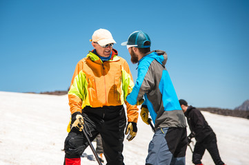 Two climbers talk on training on the right slip on the slope with an ice ax for non-stop braking