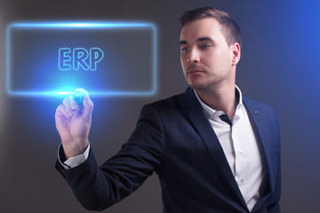 The concept of business, technology, the Internet and the network. Young businessman showing inscription: ERP