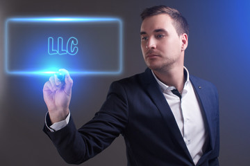 The concept of business, technology, the Internet and the network. Young businessman showing inscription: LLC