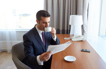 businessman reading newspaper and drinking coffee
