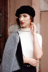 Stylish french girl in beret walking outdoors in autumn