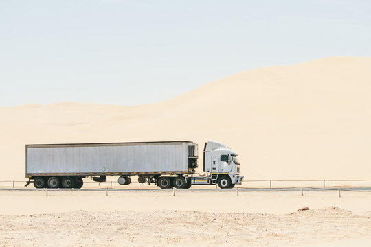 White cargo truck driving through the desert