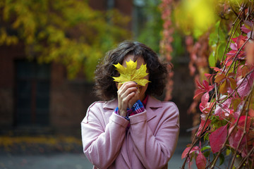 girl holds a yellow leaf - Powered by Adobe