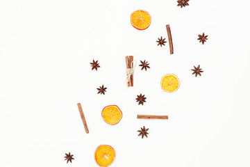 Pattern made of cinnamon, anise and dried oranges on white background. Flat lay, top view. Christmas or New Year concept.