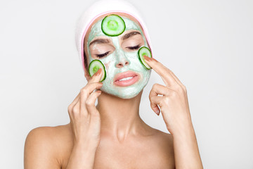 Beautiful blonde woman with a facial mask, beauty spa