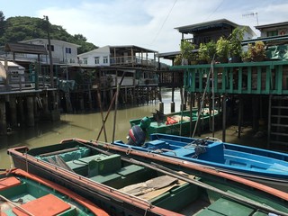 three boats with traditional village in Tai O