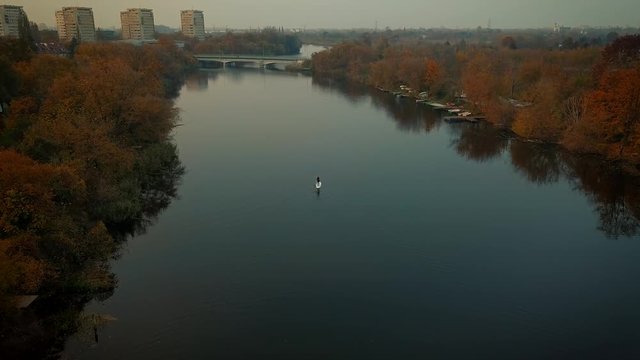 Aerial view of girl with a paddle board on the water