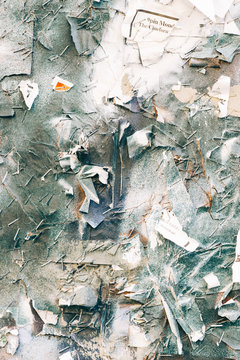 Abstract of old posted bills torn and spray painted