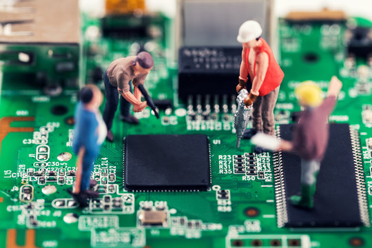 electronics repair and tech support concept - workers repairing circuit board