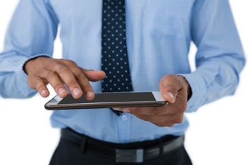 Mid section of businessman touching tablet computer