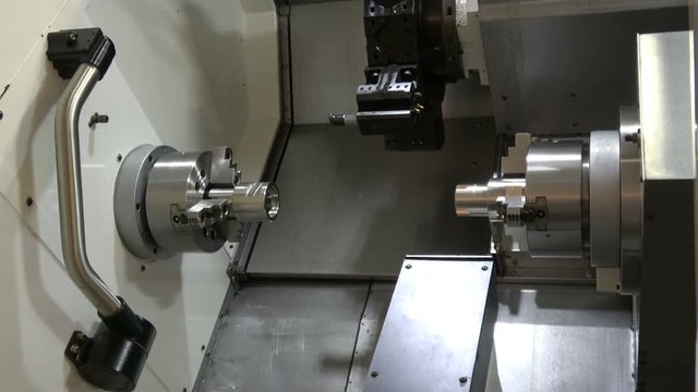 4K video footage of high speed, compact CNC lathe machine with twin spindle