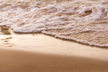 Soft wave with sandy on the beach and sunset time nature background.Summer concept,