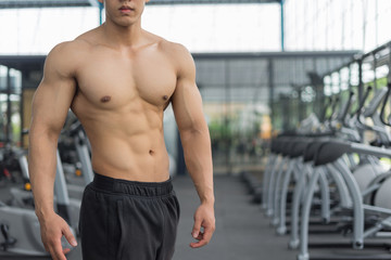 Fototapeta na wymiar Fitness man showing muscular body in gym