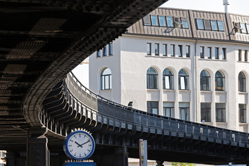 Fototapeta na wymiar clock under the curve of a suburban railway bridge in the city of Hamburg, Germany, traffic concept