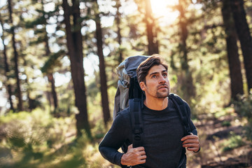 Man walking in forest wearing a backpack