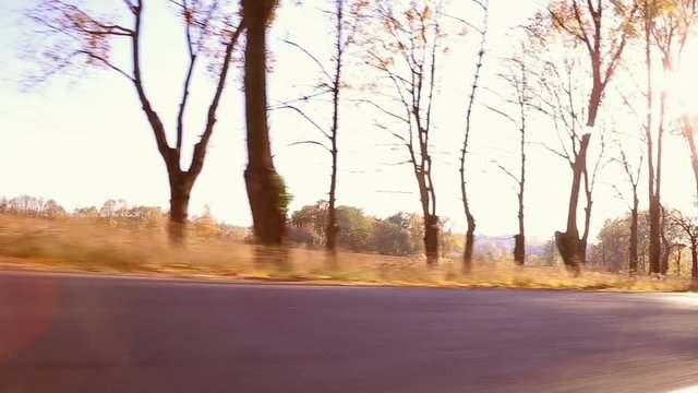 Steadycam shot of motorcyclist driving his motorbike on the road during sunset