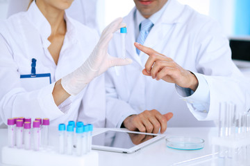 Team of  scientific researchers in laboratory studying substances or blood sample. New vaccine for pharmacology industry is s almost ready. Medicine and science concept