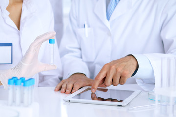 Team of  scientific researchers in laboratory studying substances or blood sample. New vaccine for pharmacology industry is s almost ready. Medicine and science concept