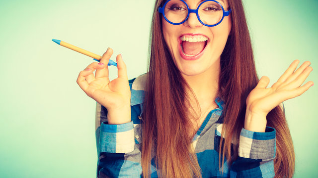 Happy nerdy woman in glasses holding pen