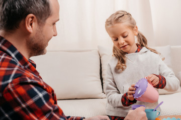 child having tea party with father