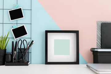 Square photo frame and school supplies on colorful desk. Mock up, template.