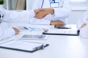 Doctors shaking hands to each other finishing up medical meeting