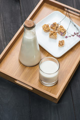 Dairy products. A bottle of milk and glass of milk serve with almond candies on a rustic wooden table.