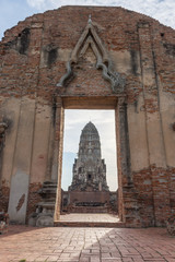 Ancient wall with pagoda in the background at Wat Ratchaburana Temple Ayutthaya