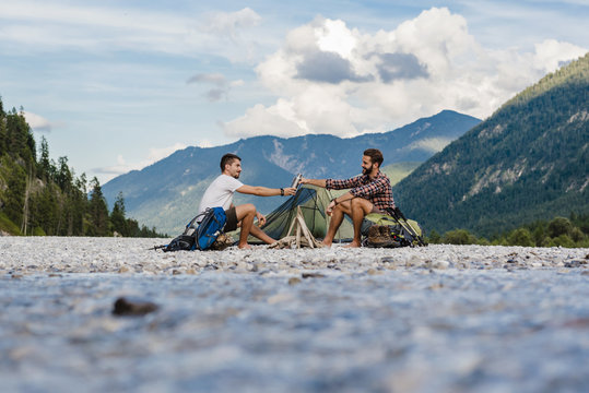 Germany, Bavaria, two hikers camping on gravel bank