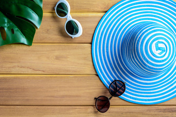 top view blue hat and sunglasses on a wooden table