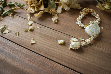 Dried flower garlands with dried leaves on old wooden floor.
