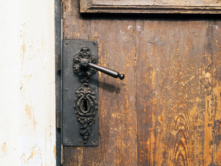 Old wooden door with metal handle and lock