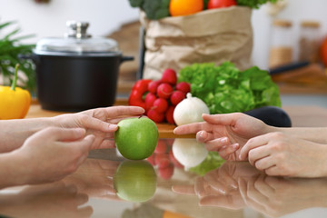 Close-up of human hands are gesticulate over a table in the kitchen. Women choosing menu or making online shopping. So much ideas for tasty cooking