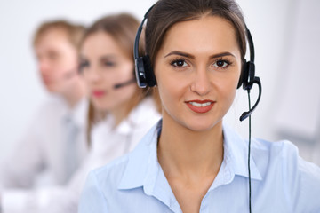 Call center. Focus on beautiful business  woman in headset