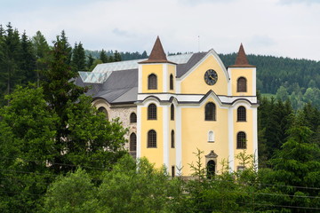 Fototapeta premium Church of Assumption in sunny mountains country, Neratov, Orlicke hory