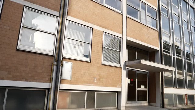 Establishing shot of high school exterior, a bit old and run-down. Vertical panning movement