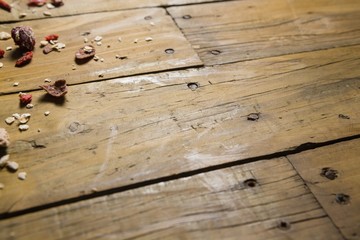 Scattered dry fruits and breakfast cereals on wooden table
