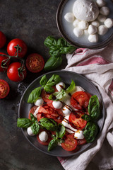 Italian caprese salad with sliced tomatoes, mozzarella cheese, basil, olive oil. Served in vintage...