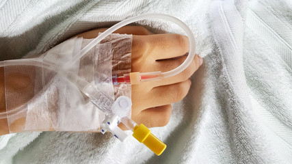 patient with saline drip bag on bed in hospital