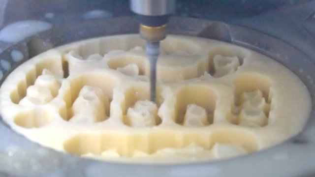 Automatic Process Dental Milling Machine Carving Out the Exact Shape Model of Human Teeth in a Dental Lab Close-up. Processing of carving out shape of human teeth from dental milling machine.