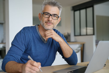 Middle-aged man working from home-office on laptop