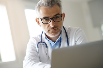 Doctor in office working on patient file