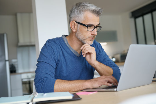 Middle-aged man working from home-office on laptop